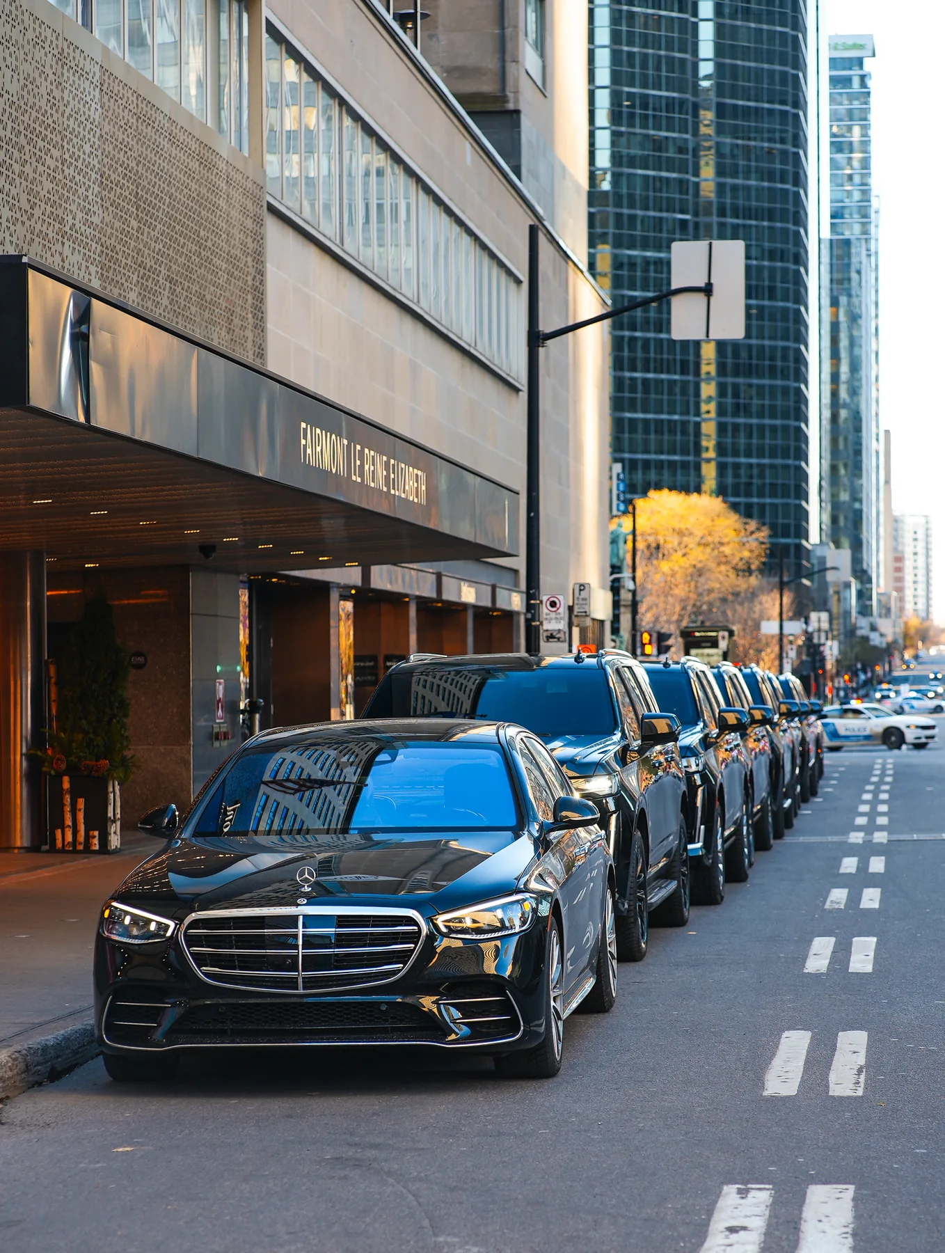 Berline Mercedes et file de VUS devant le Fairmont Le Reine Elizabeth.