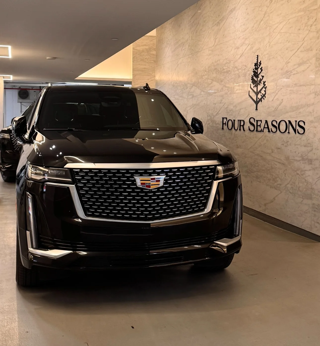 Cadillac Escalade noir près de l’enseigne de l’hôtel Four Seasons.